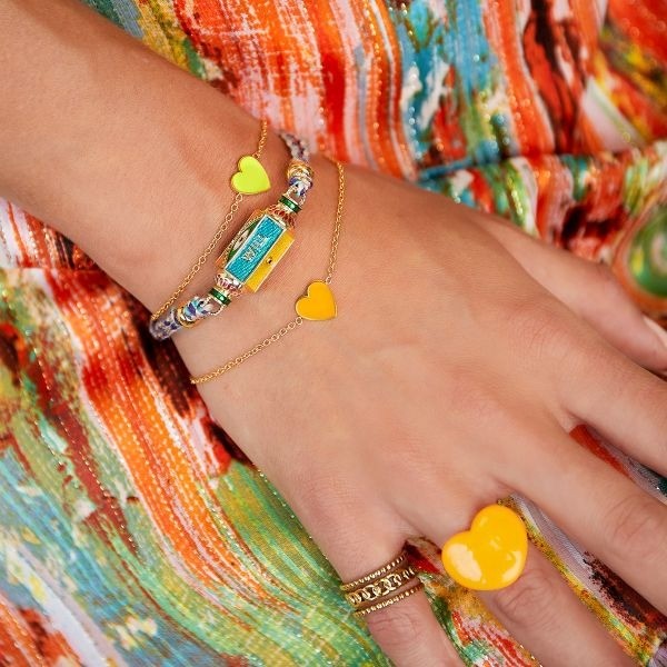 Roestvrijstalen armband met enkele hartvormige bedel. De bedel is gekleurd met emaille Kleur: Goud Kleur hartje: Oranje Materiaal: Stainless Steel / Nickel Free Untermaterial : Emaille Afmeting: ca. 16cm + 3cm Merk: Yehwang Kleur foto kan iets afwijken van origineel