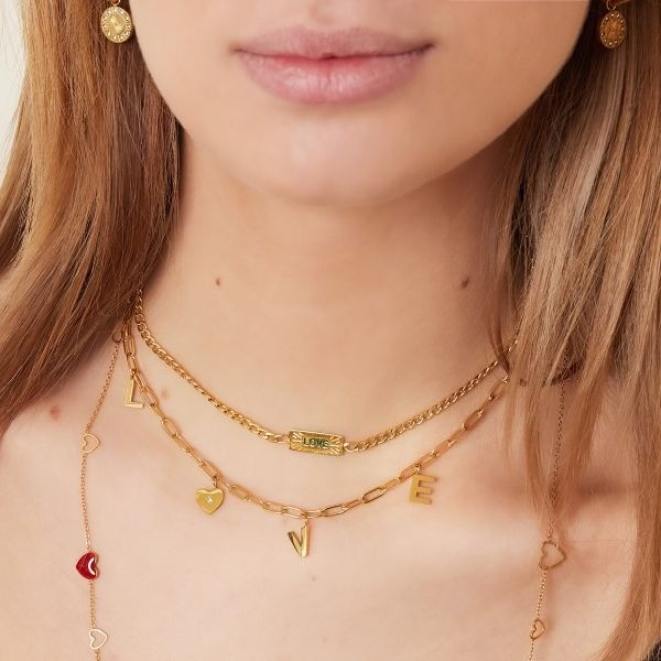 Roestvrijstalen ketting met het woord "Love" en een hartje met een zirkoonsteentje Kleur: goudkleur Afmeting: ca. 39cm + 5cm Materiaal: stainless steel Merk: Yehwang Kleur foto kan iets afwijken van origineel